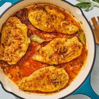 An overhead photo of braised chicken breasts in a skillet.