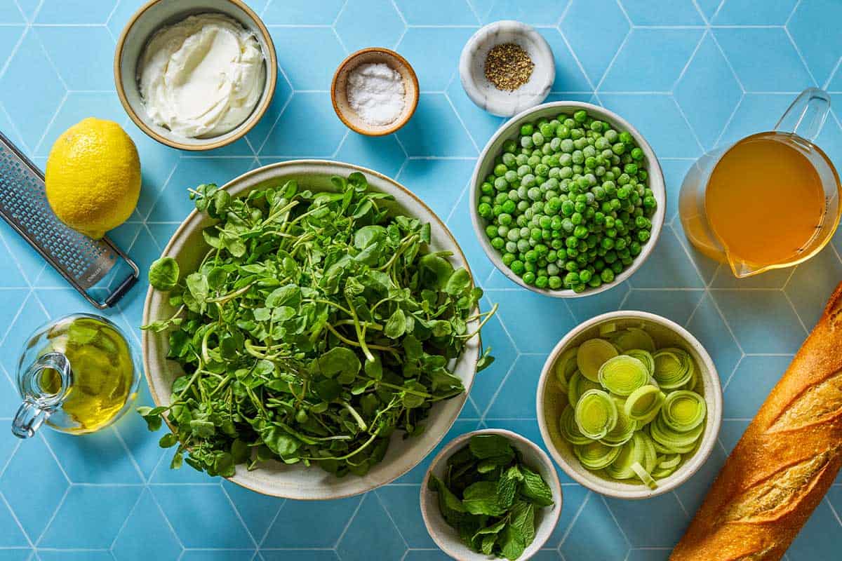 Ingredients for watercress soup, including watercress, mint, peas, leeks, olive oil, yogurt, salt, pepper, lemon, French bread, and chicken stock.