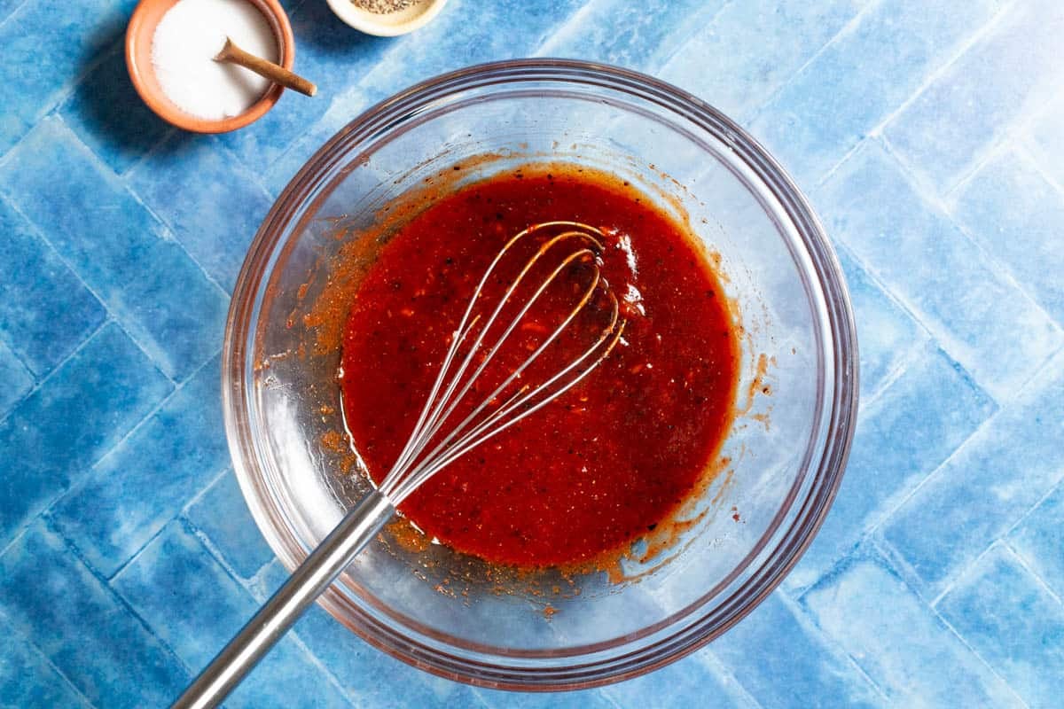 Finished honey-harissa marinade with harissa, tomato paste, honey, lemon juice, urfa biber, coriander, paprika, garlic, and olive oil.