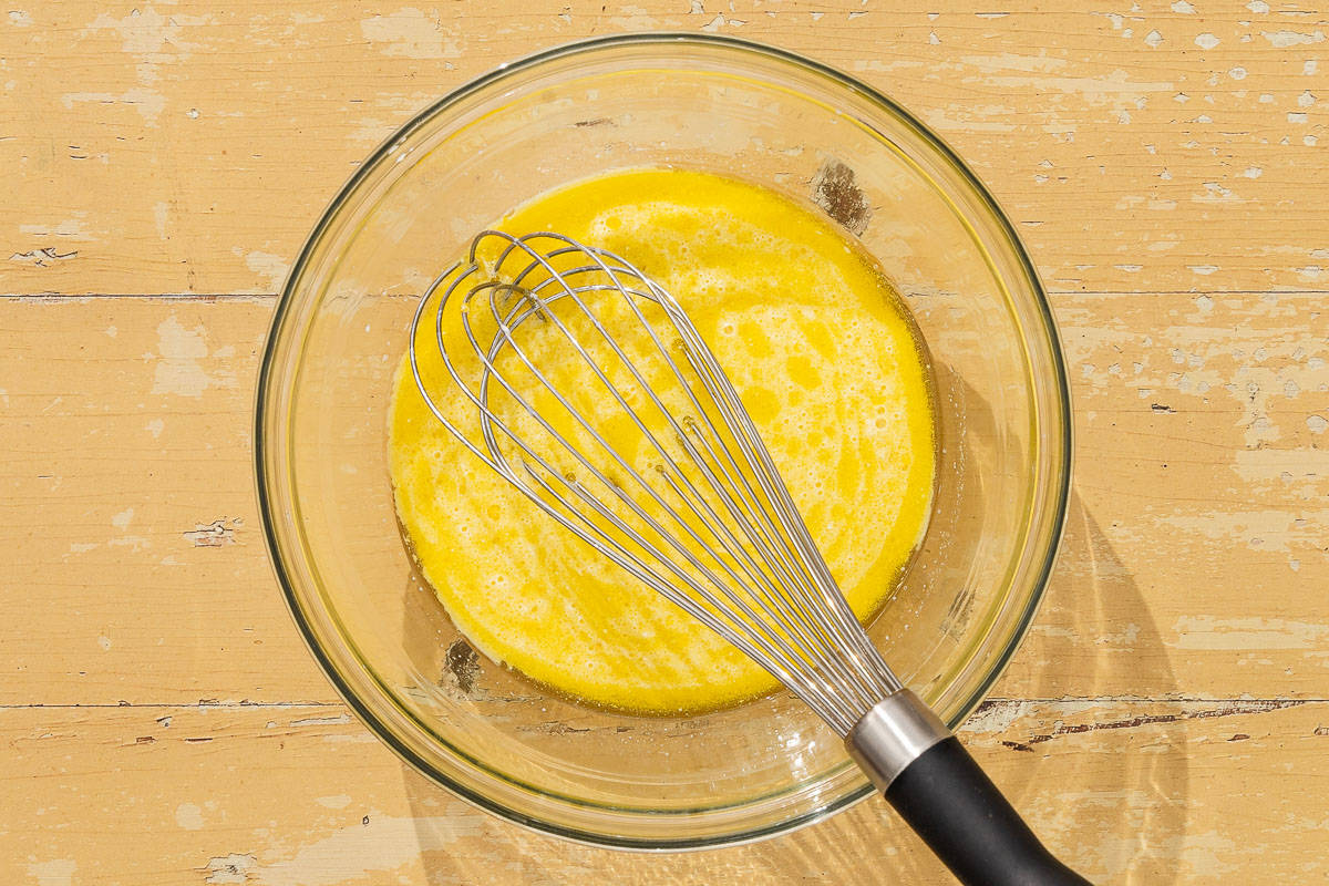 the milk, olive oil, zest and vanilla for the shortcake dough mixed together in a bowl with a whisk.