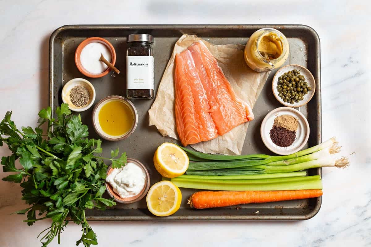 Ingredients for salmon salad including salmon, salt, pepper, olive oil, green onions, celery, carrot, capers, parsley, greek yogurt, dijon mustard, lemon, coriander, sumac, and urfa biber.