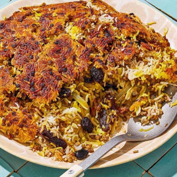 Adas Polo on a serving plate with a serving spoon.