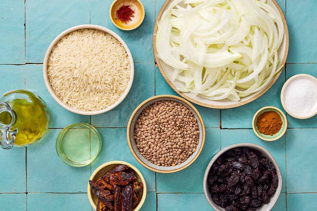 Ingredients for Adas Polo including rice, saffron, brown lentils, cinnamon, olive oil, onions, raisins, salt, dates, vegetable oil.