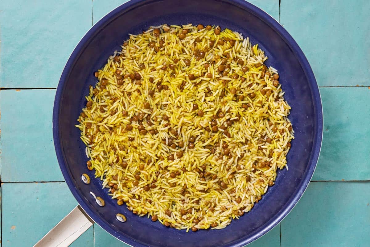Lentils and rice cooking together in a skillet.