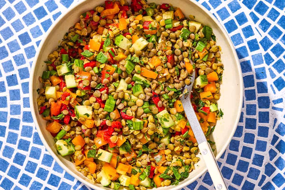 Lentil salad in a serving bowl with a spoon.