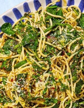 An overhead photo of za'atar garlic spinach pasta on a serving platter with a fork next to a small bowl of za'atar.