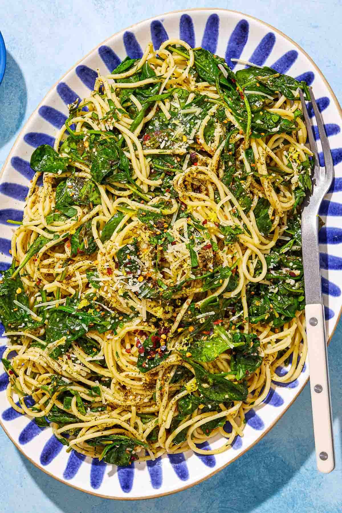 An overhead photo of za'atar garlic spinach pasta on a serving platter with a fork.