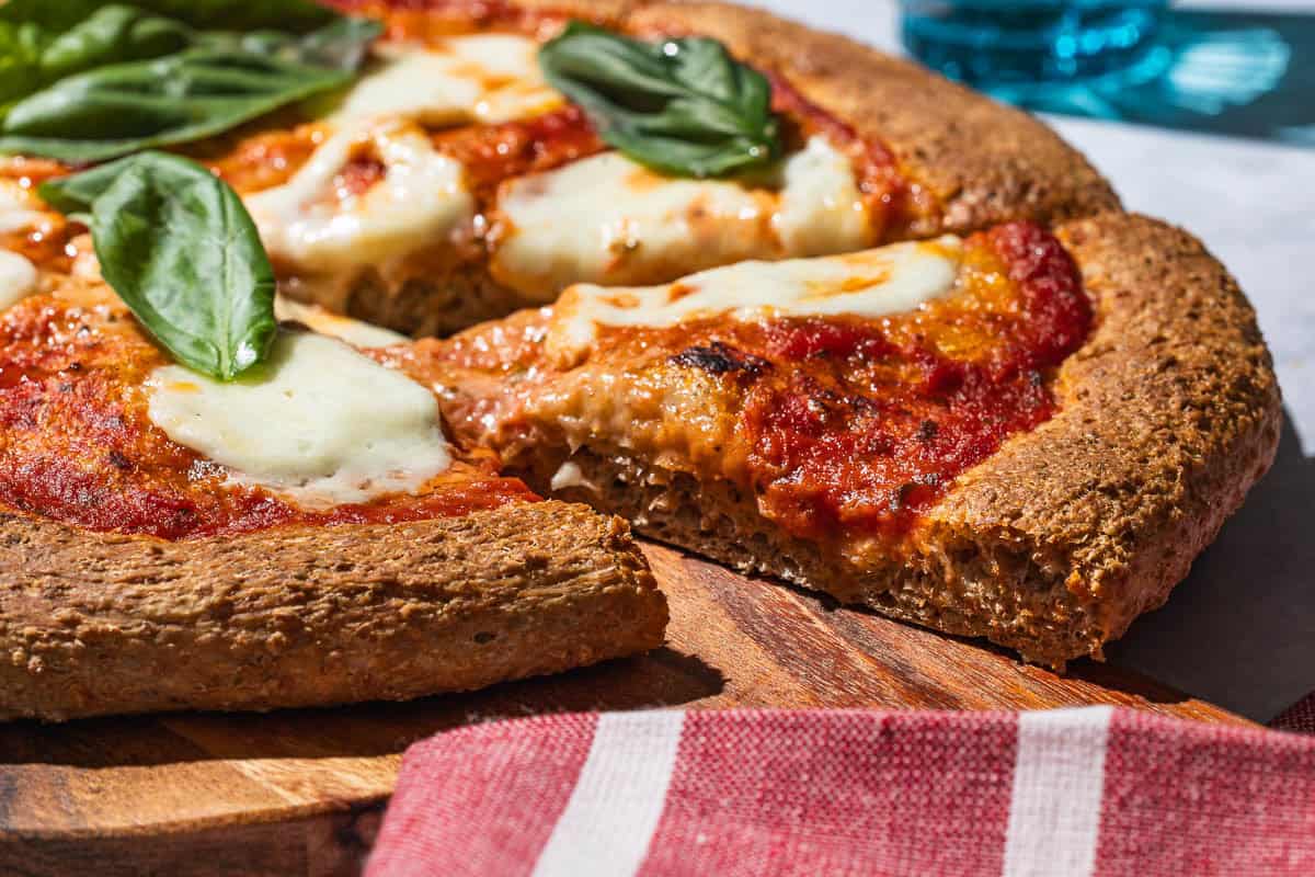 An very close up photo of slices of pizza maade with a whole wheat crust.