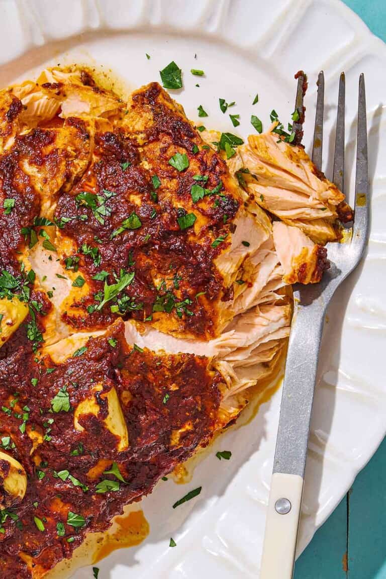 A close up of Turkish style salmon on a serving platter with a fork.