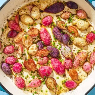 An overhead close up photo of roasted radishes in a skillet garnished with chives.