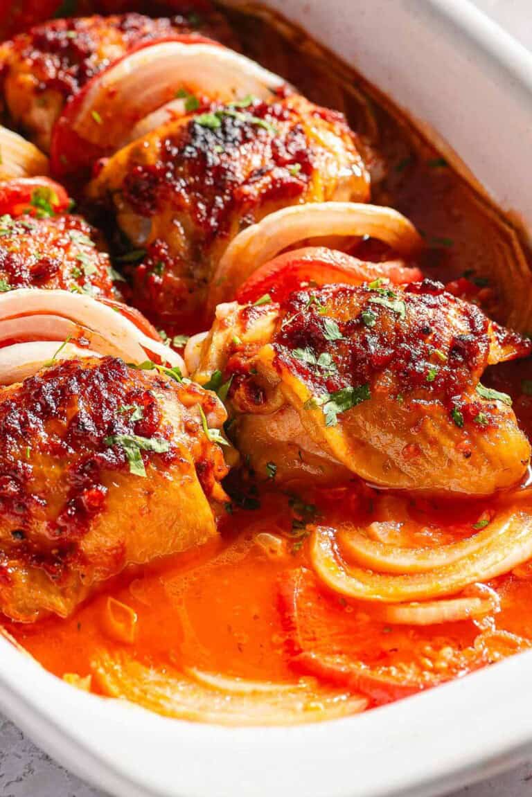 A close up of baked chicken thighs in a baking dish.