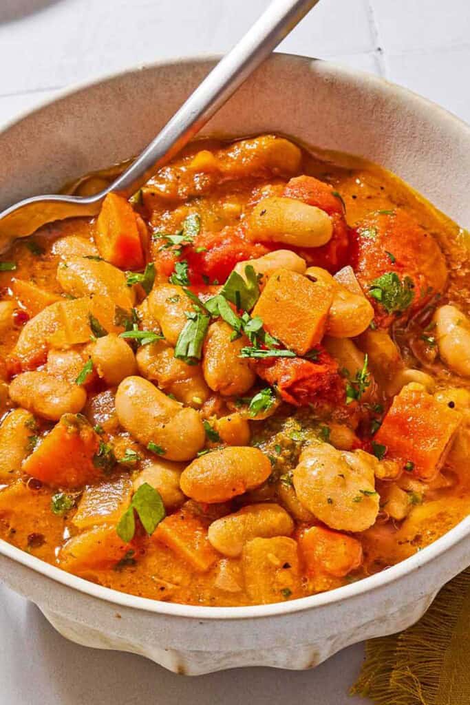 White bean stew in a bowl with a spoon.