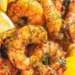 Air fryer shrimp with lemon wedges.