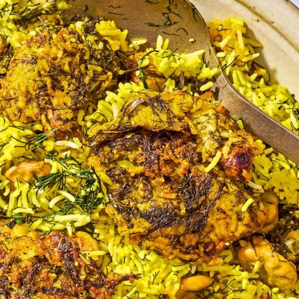 The baghali polo on a platter with a spoon.