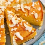 Two slices of the basbousa on a platter with the rest of the cake.