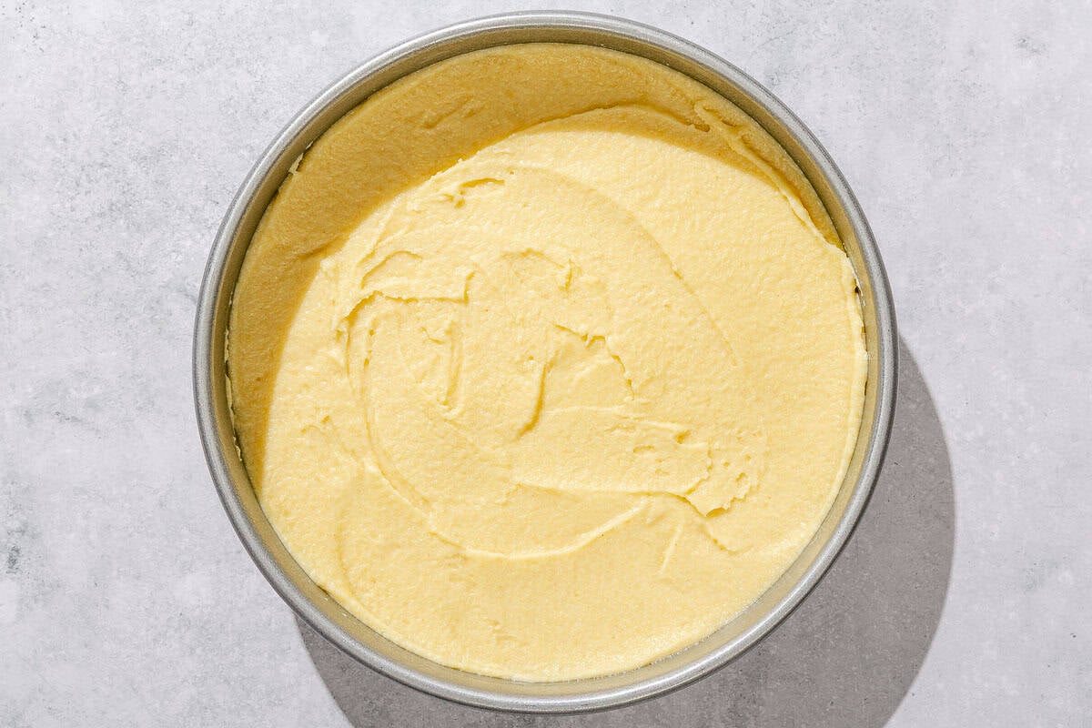The batter fore the basbousa recipe in a round cake pan.