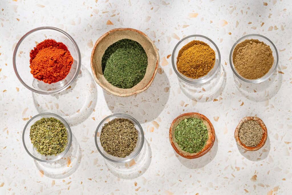 Ingredients for fish seasoning including sweet paprika, dried dill, ground coriander, ground cumin, dried oregano, dried thyme, dried tarragon, and ground black pepper.