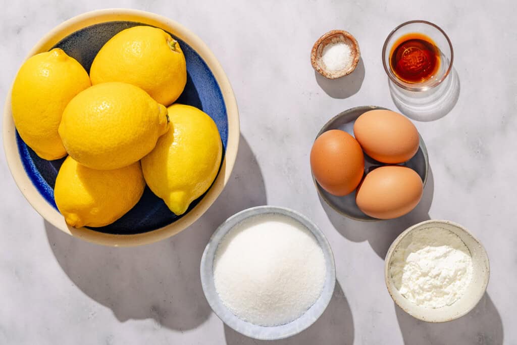 Lemon pudding ingredients including whole lemons, sugar, corn starch, eggs,