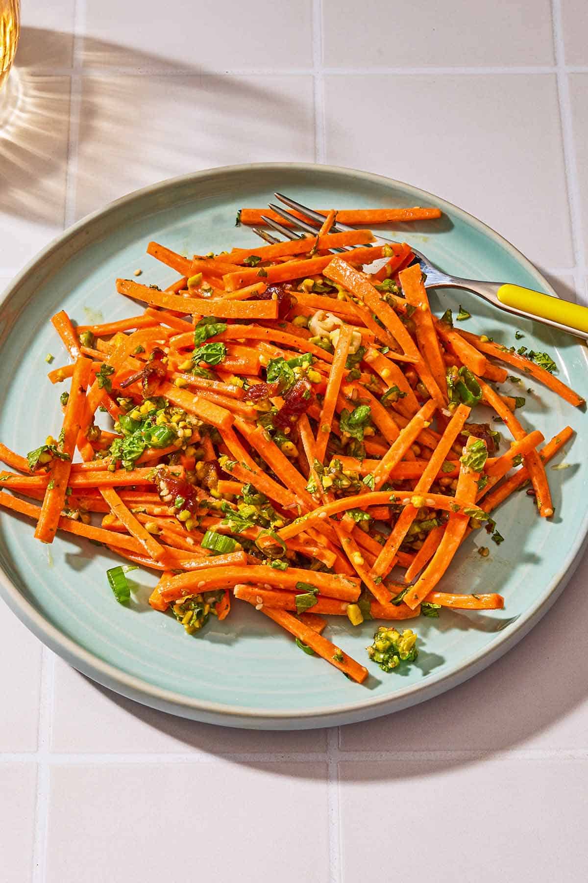 The carrot salad with herbs on a plate with a fork.