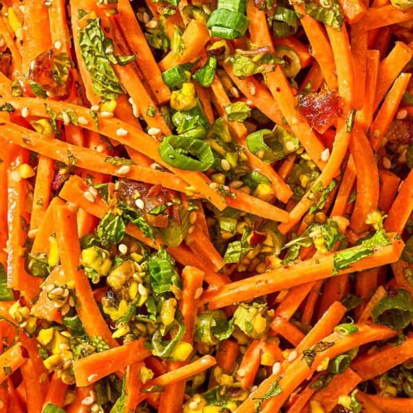 A close up of carrot salad with herbs.