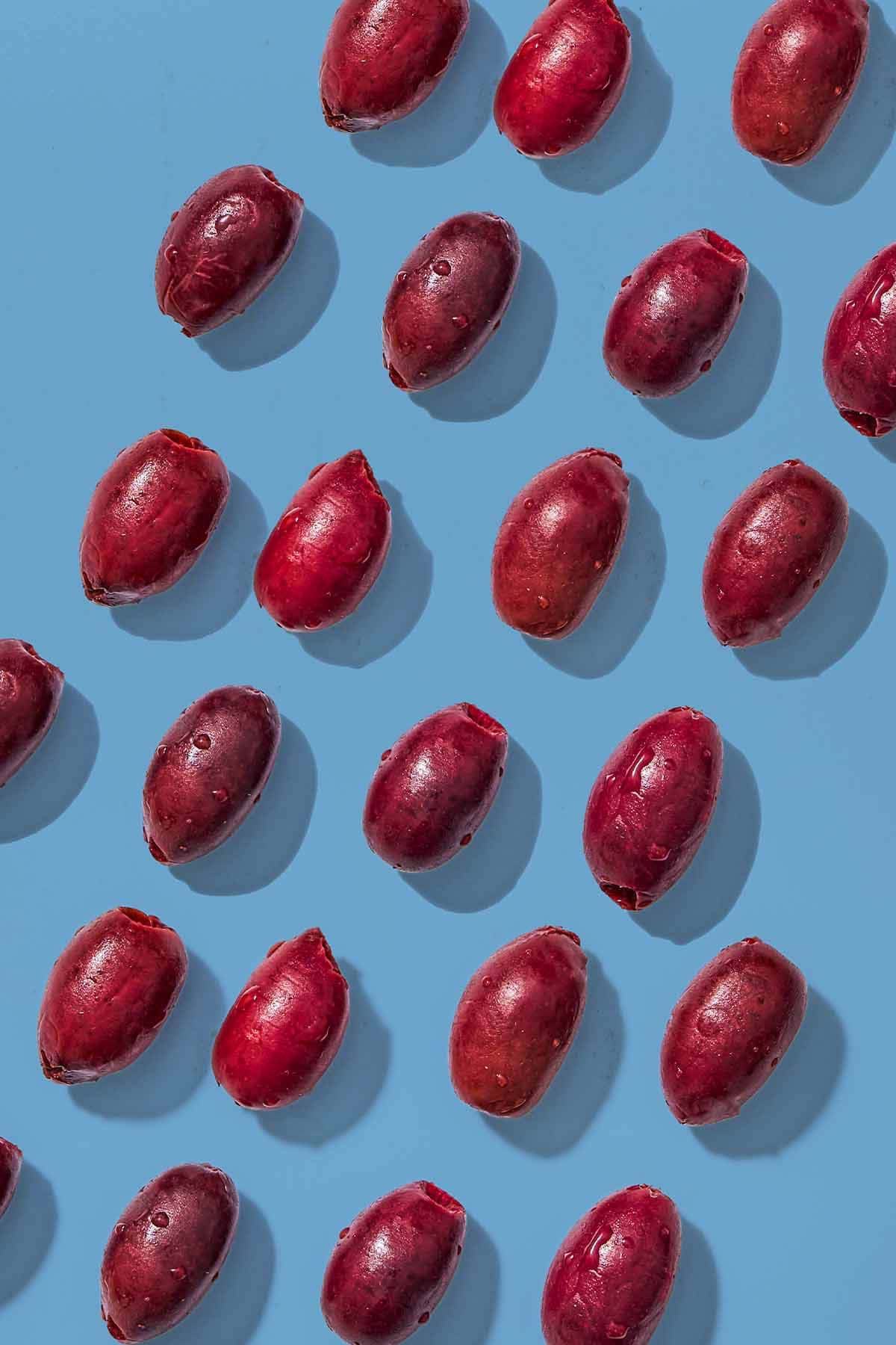 Several kalamata olives placed evenly in rows.