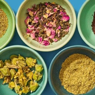Five bowls, each containing different flavored tea leaves.