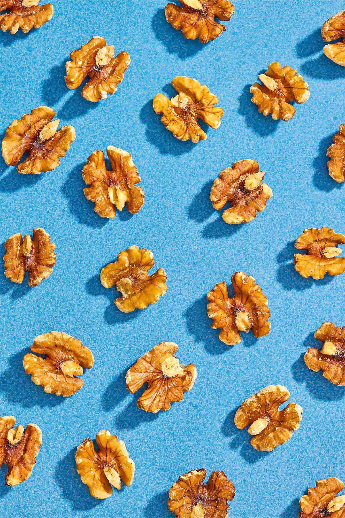 Several walnuts spread evenly on a blue background.