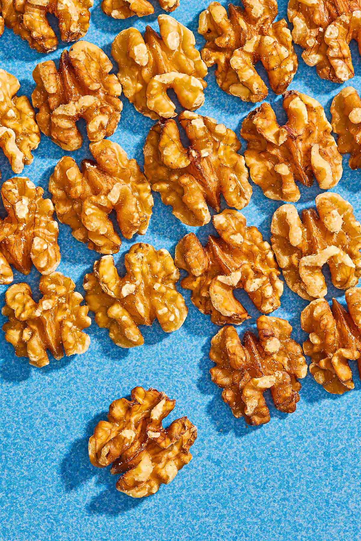 Several walnuts spread evenly on a blue background.