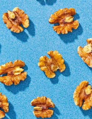 Several walnuts spread evenly on a blue background.