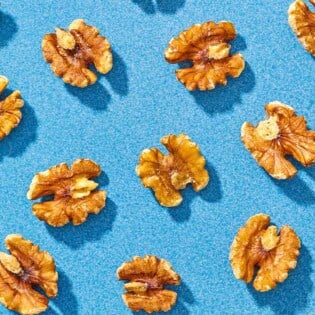 Several walnuts spread evenly on a blue background.