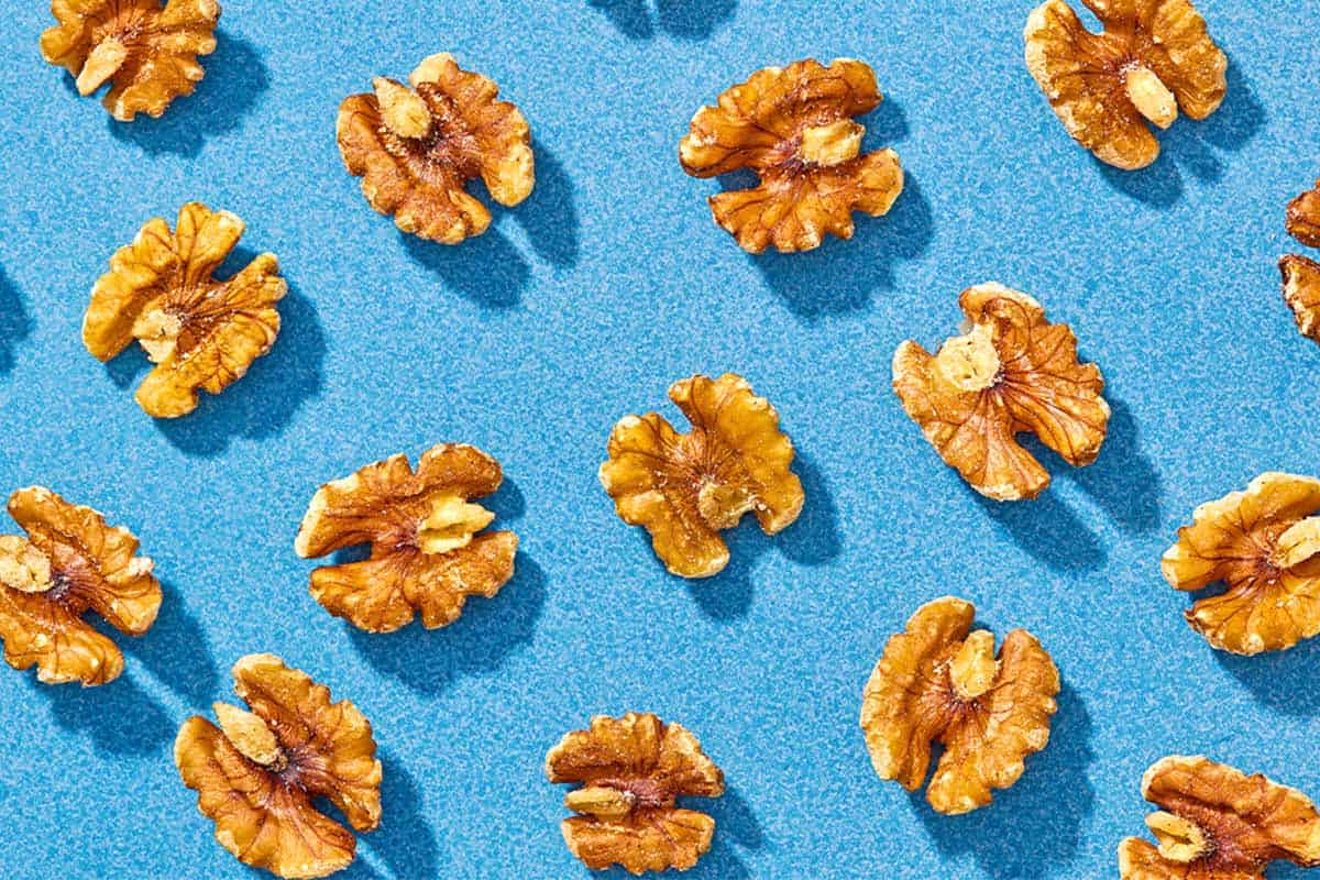 Several walnuts spread evenly on a blue background.