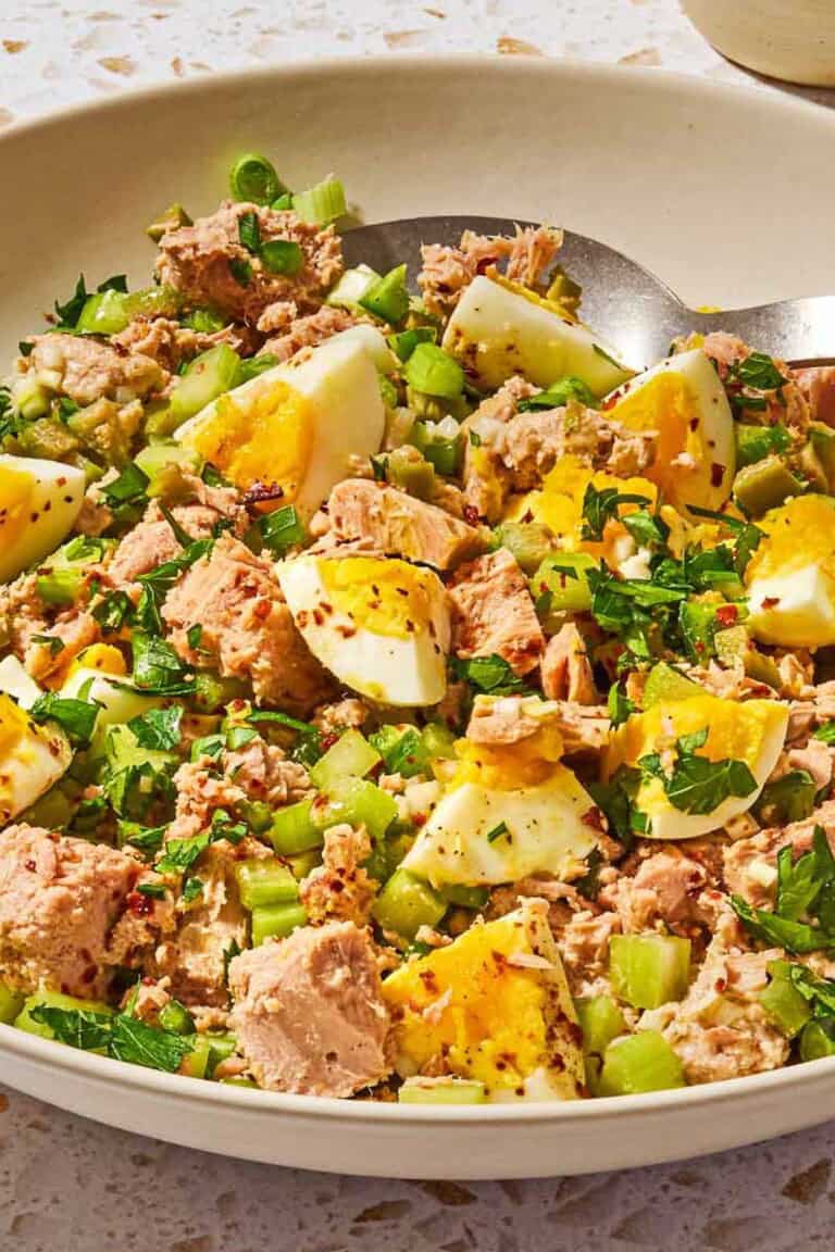 The tuna salad recipe with egg in a serving bowl with a spoon.