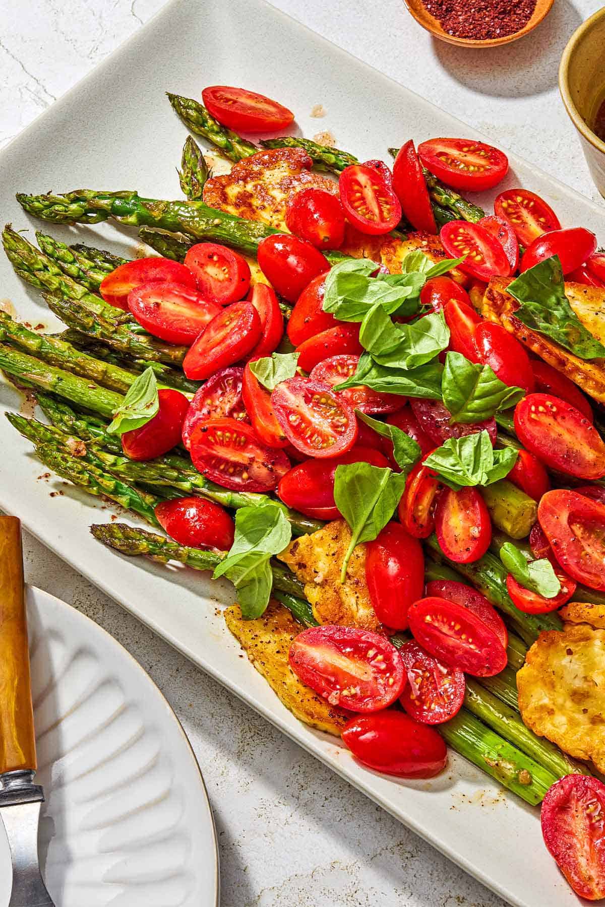 Roasted Asparagus Salad with Fried Halloumi and Fresh Tomatoes on a serving platter.