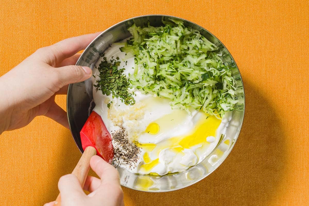 The ingredients for the Maast O'Khiar being stirred together in a bowl with a spatula.