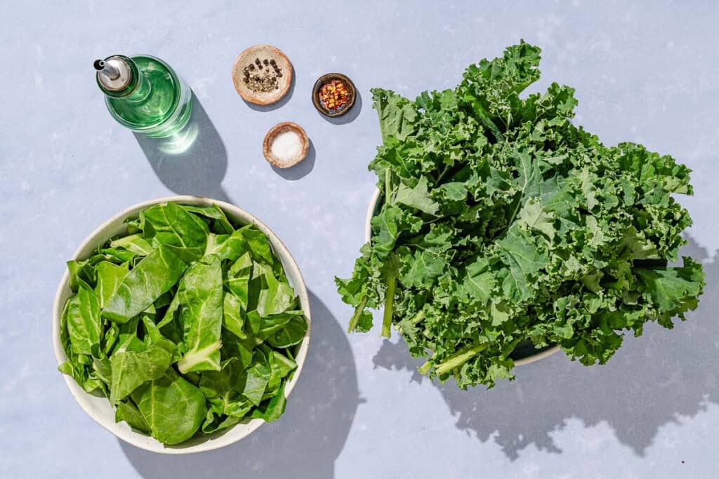 Ingredients for horta including Swiss chard, Kale, olive oil, salt, pepper, red pepper flakes.