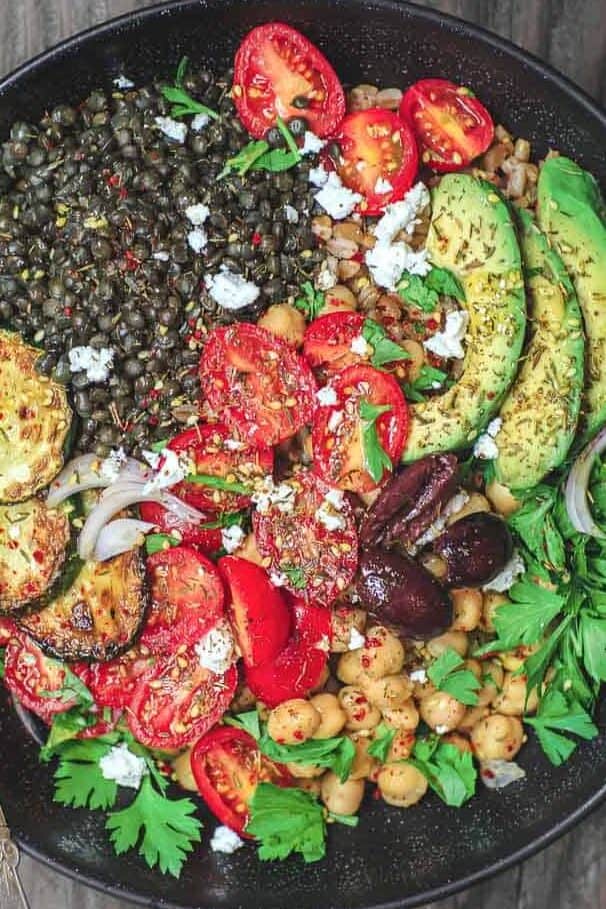 Mediterranean Grain Bowls with lentils, zucchini, avocados, tomatoes and topped with feta cheese.