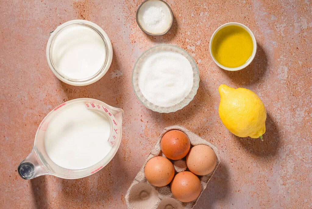 Ingredients for olive oil ice cream including whole milk, heavy cream, granulated sugar, eggs, olive oil, lemon, and flaky sea salt.