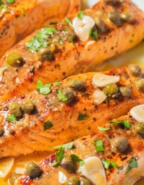 A close up of 4 salmon piccata fillets.