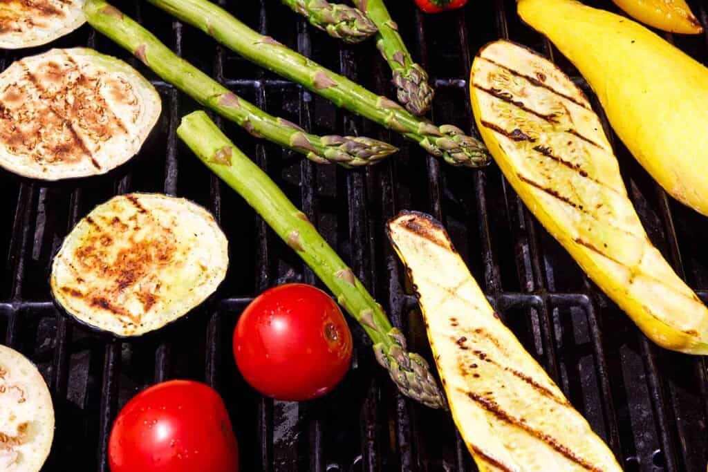 A variety of vegetable cooking on a grill.