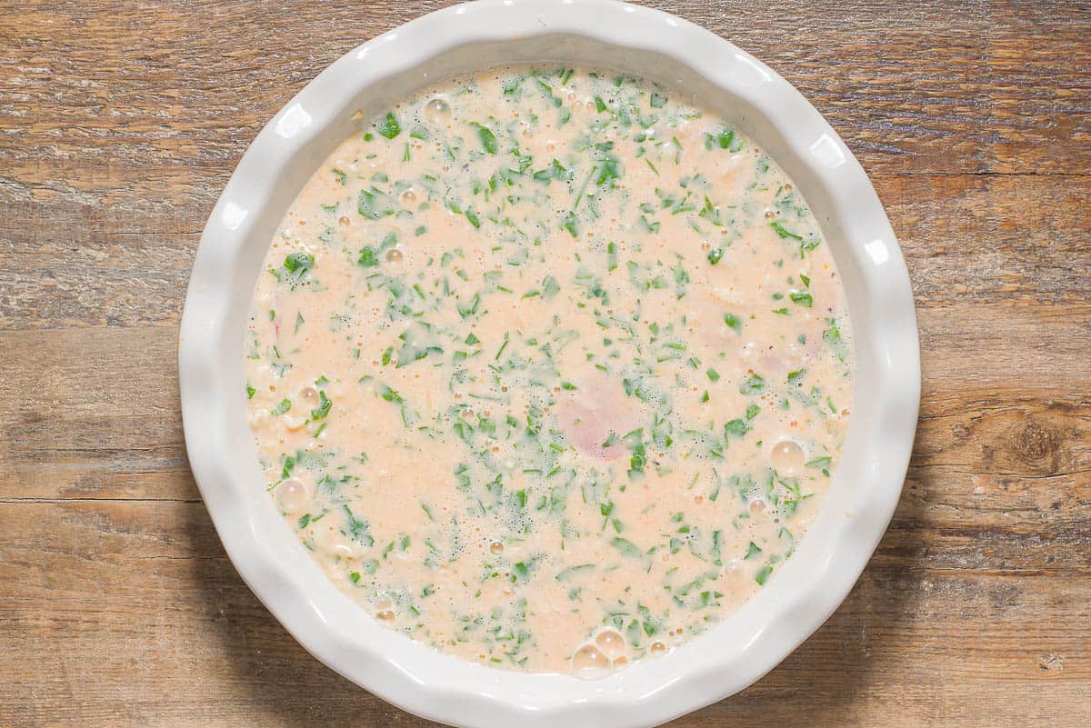 The unbaked quiche mixture in a baking dish.