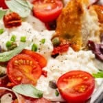 A close up of burrata salad on a platter.