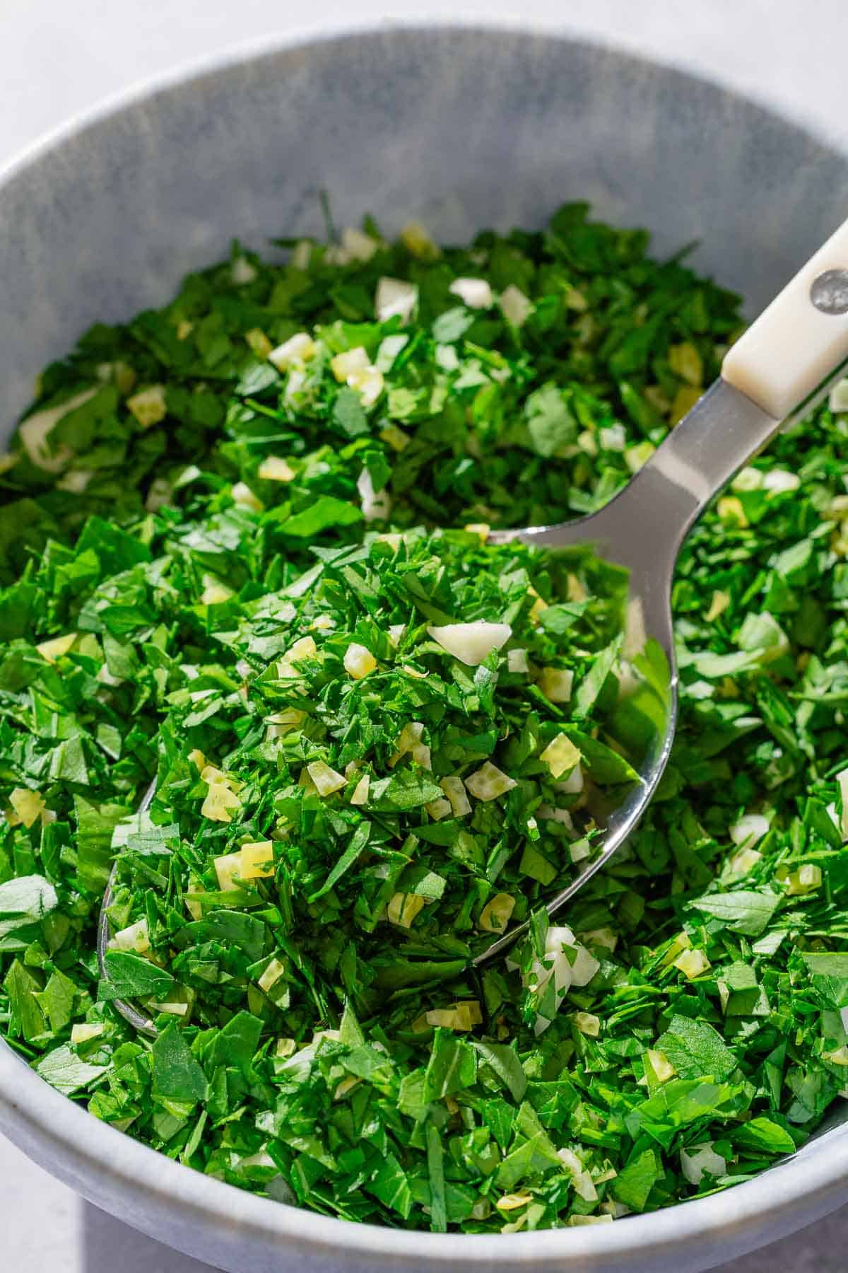 Gremolata in a bowl with a spoon.