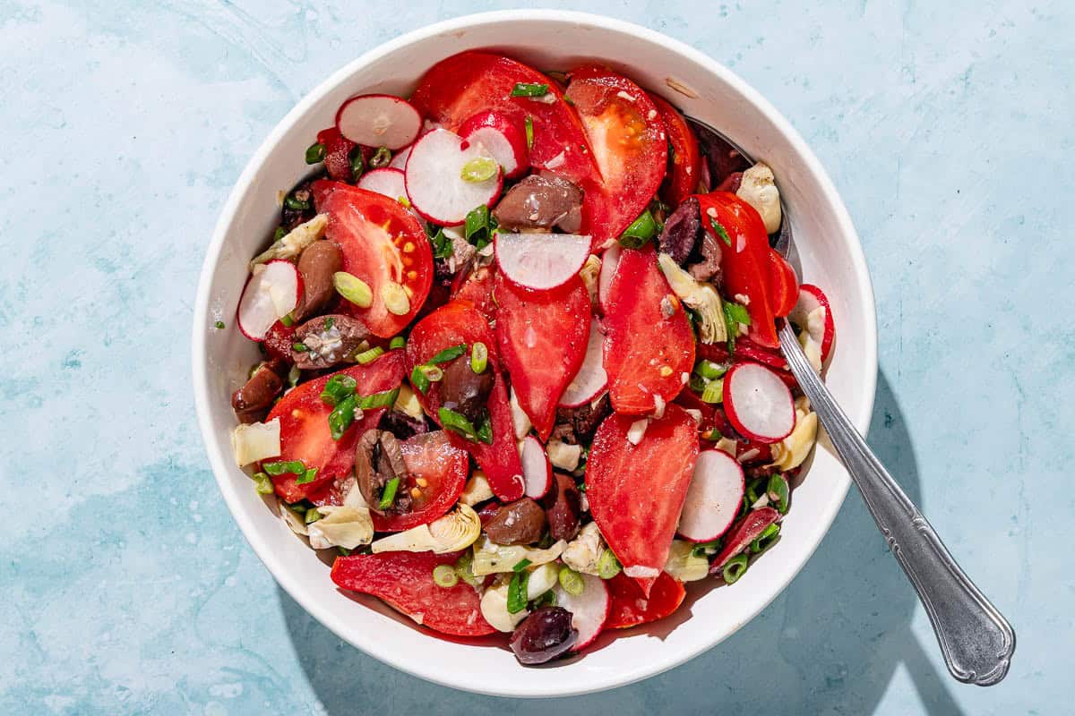 A bowl with veggies for the pan bagnat with a spoon.