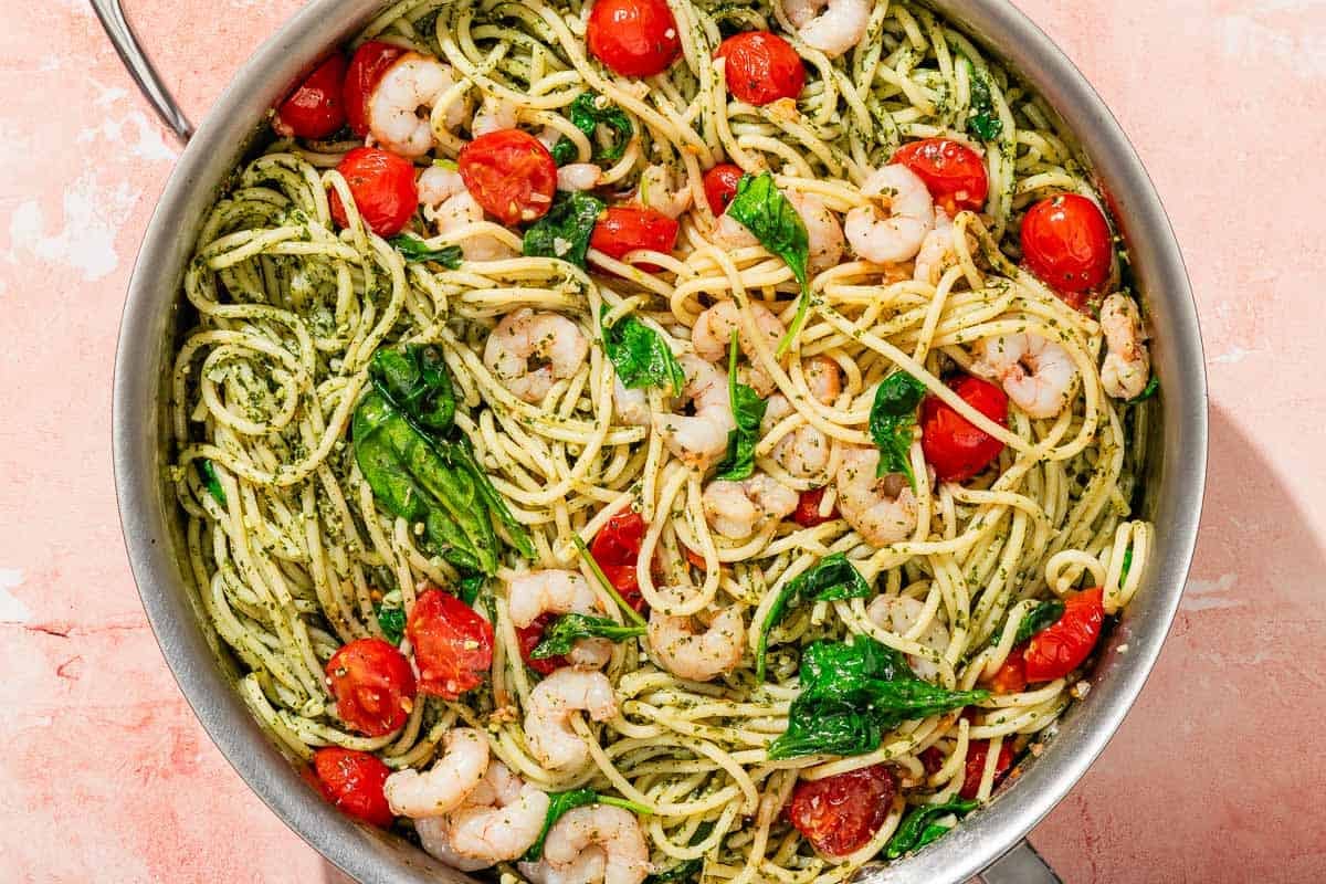 Shrimp pesto pasta in a tall-sided skillet.