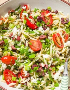 Orzo salad in a bowl with a spoon.