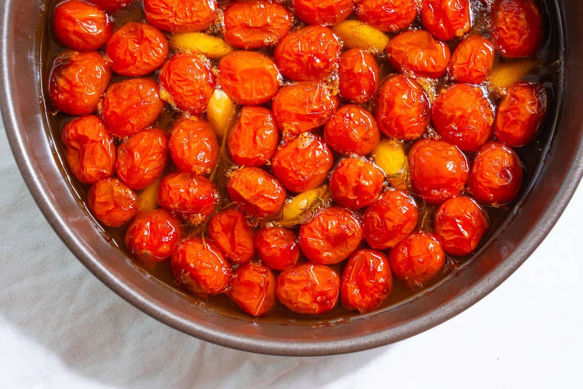 The ingredients for the tomato confit cooking together in a saucepan.