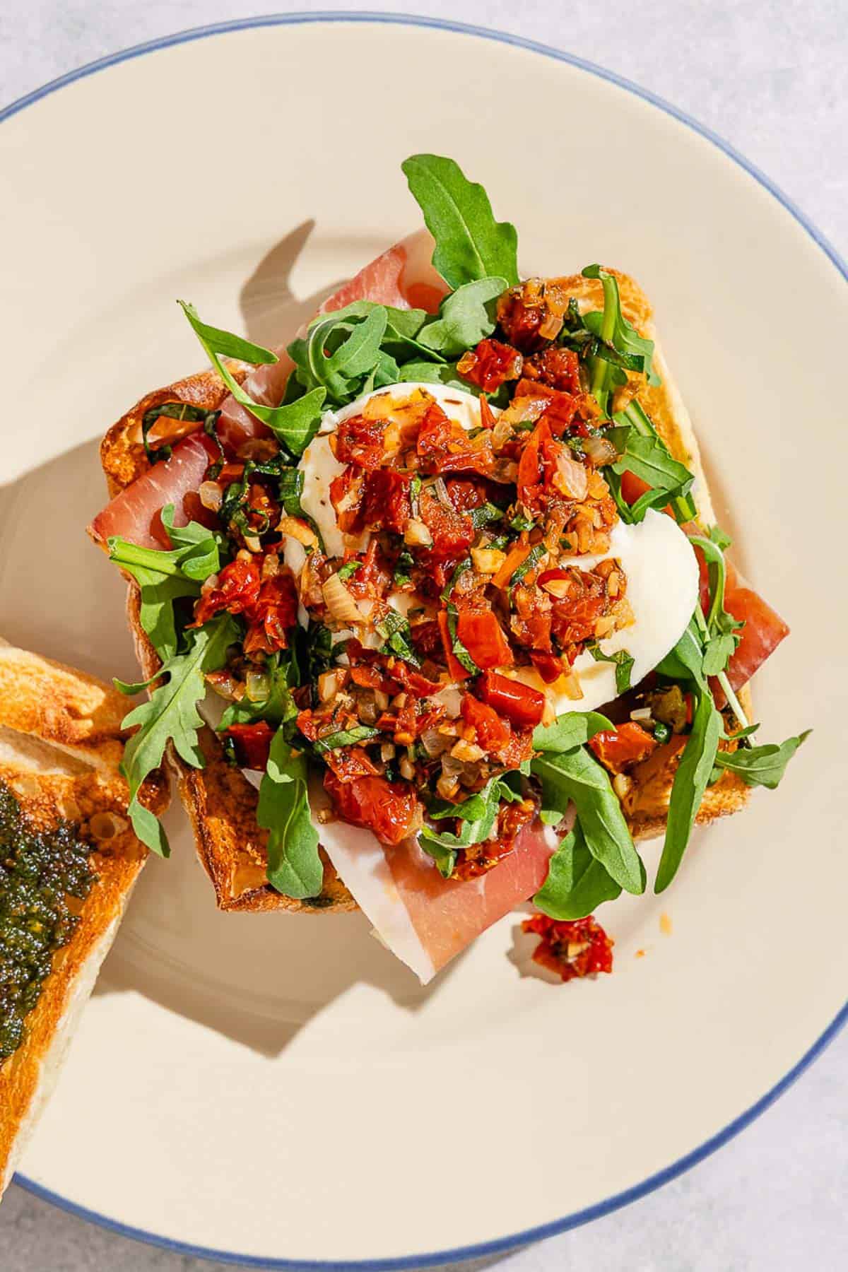 An open-faced breakfast sandwich on a plate.