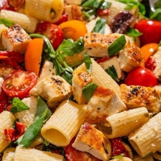 Chicken pasta salad in a serving bowl with a spoon.