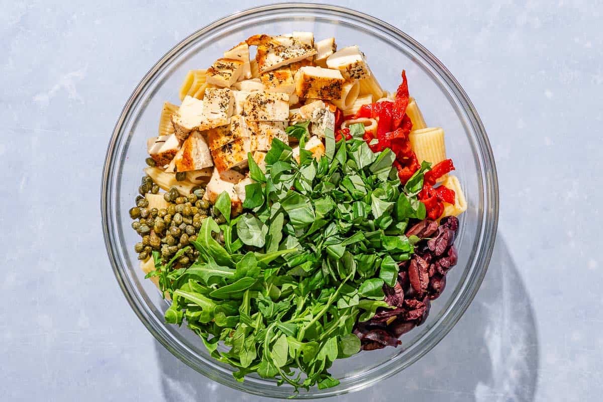 The ingredients for the chicken pasta salad in a bowl just before being mixed together.