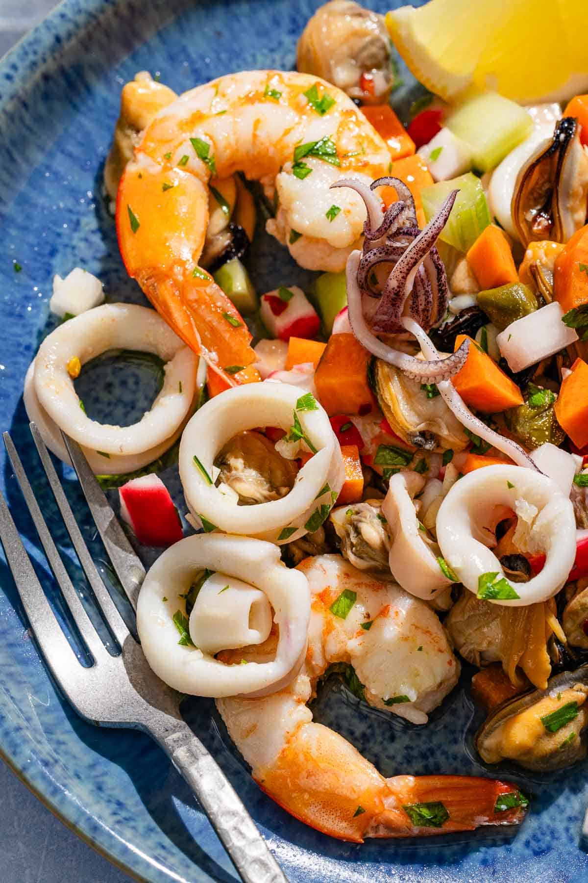 A serving of the seafood salad on a plate with a fork.